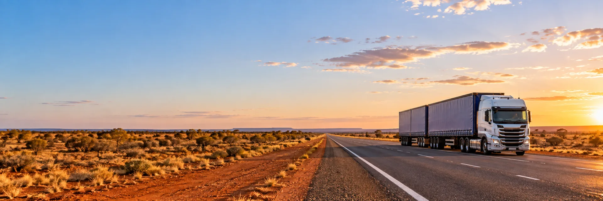 B-double truck on a long straight outback highway under a wide sky
