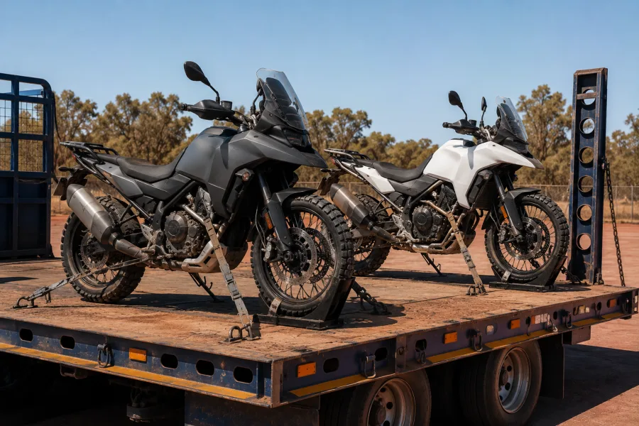 Two adventure motorcycles chocked and strapped on a trailer deck