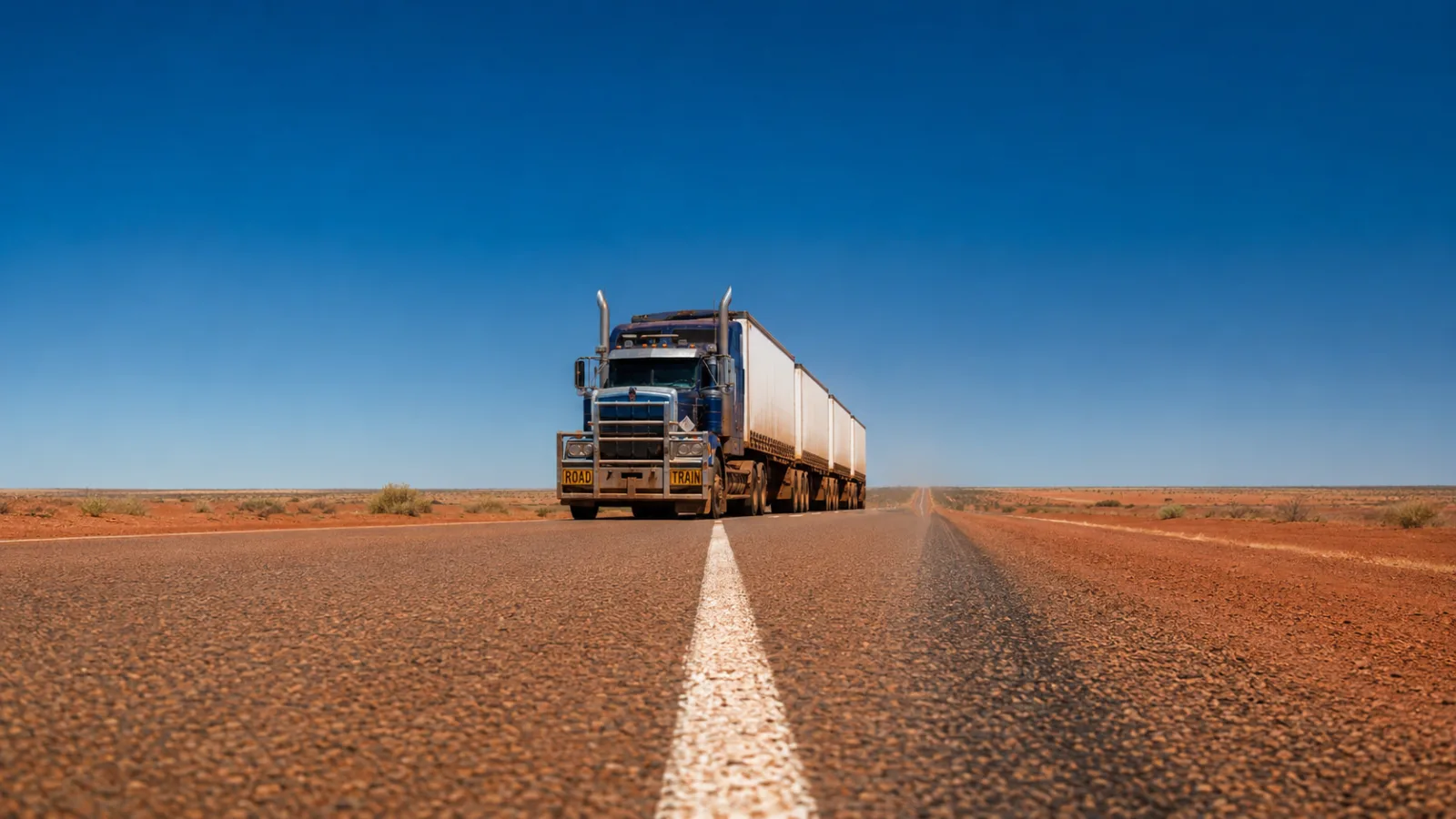Road train on the Stuart Highway running dead straight through the red centre