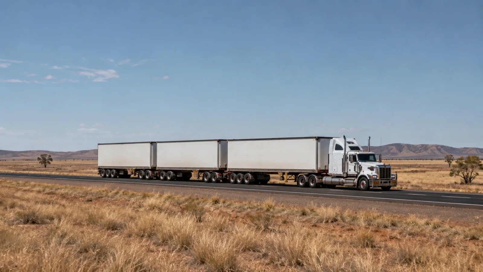 Road train crossing the open Barkly Tableland grassland under a wide sky