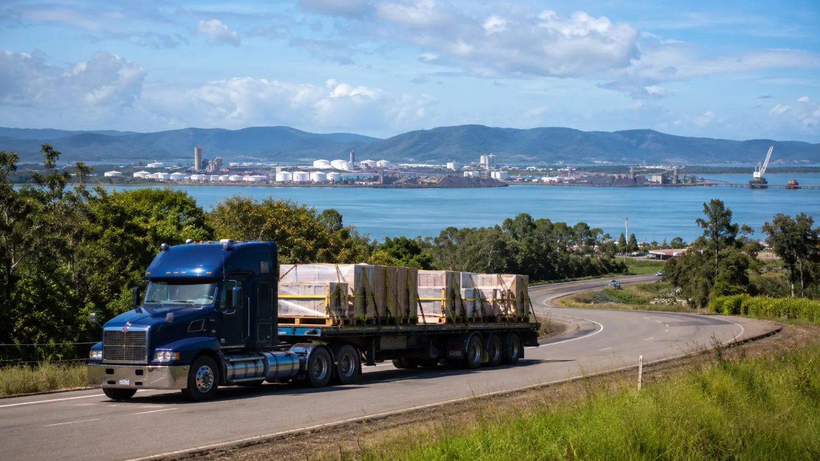 Trailer with crated components approaching Gladstone harbour and industry