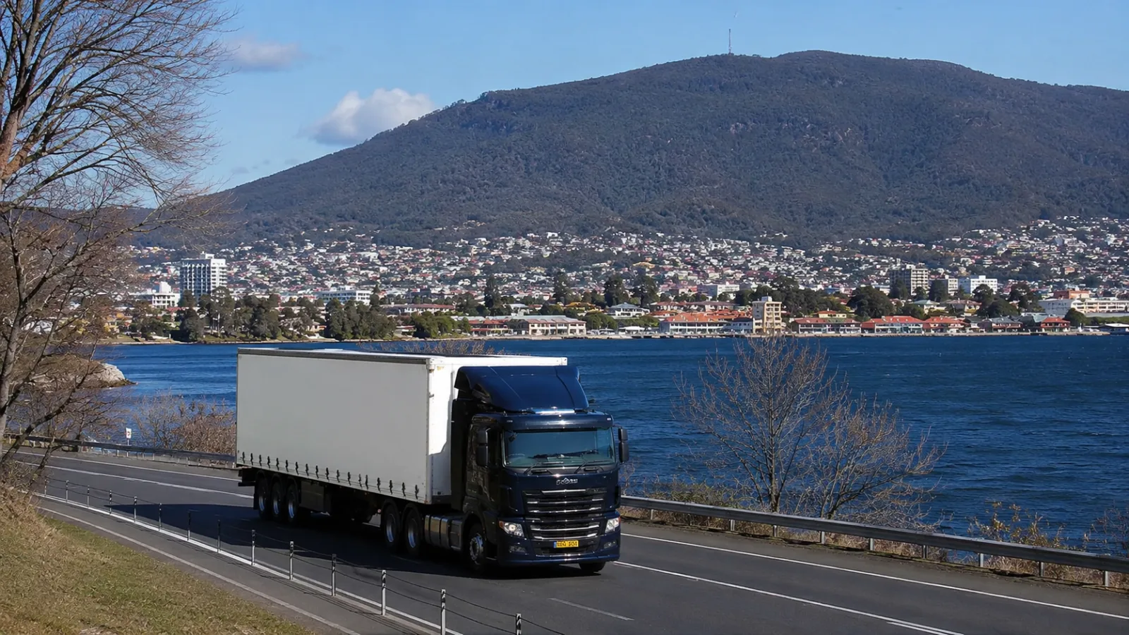 Semi-trailer on the road into Hobart with the Derwent and the mountain behind