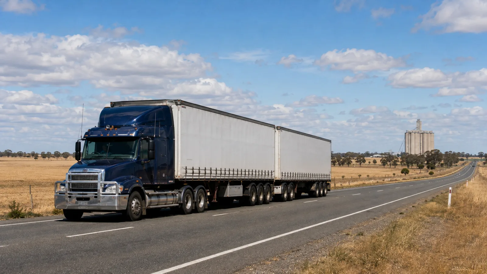 B-double on the Newell Highway through cropping country with grain silos ahead