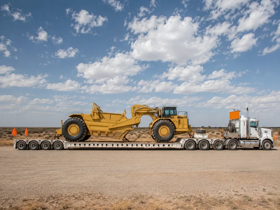 Oversize machine on a multi-axle low-loader beside the Stuart Highway