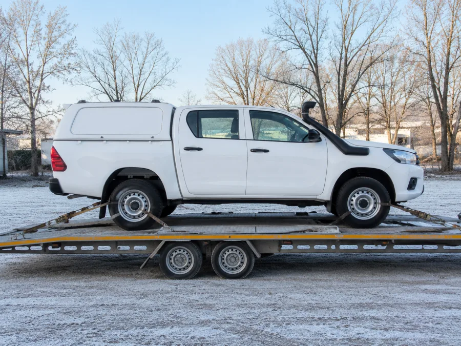 Four wheel drive utility strapped on a carrier deck on a frosty Canberra morning