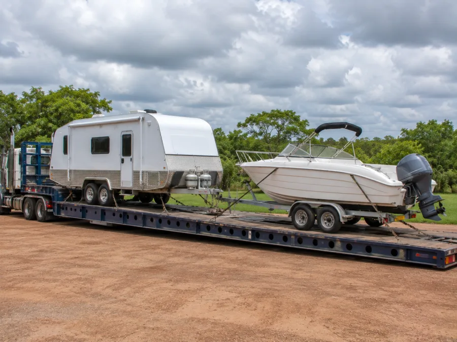 Caravan and boat loaded on a drop-deck arriving in the Top End for the dry season