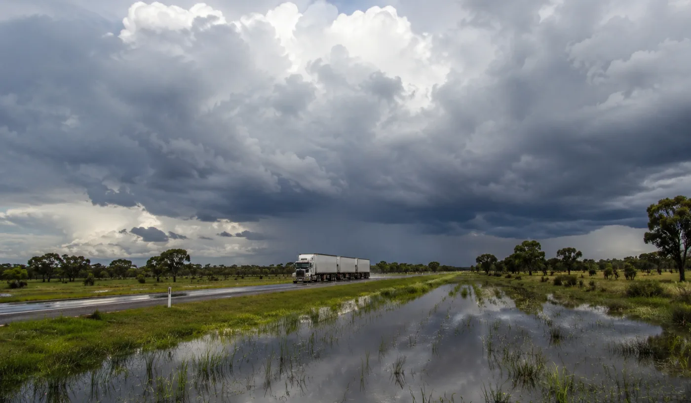 Road train on the Stuart Highway with floodwater across the savannah in the wet season