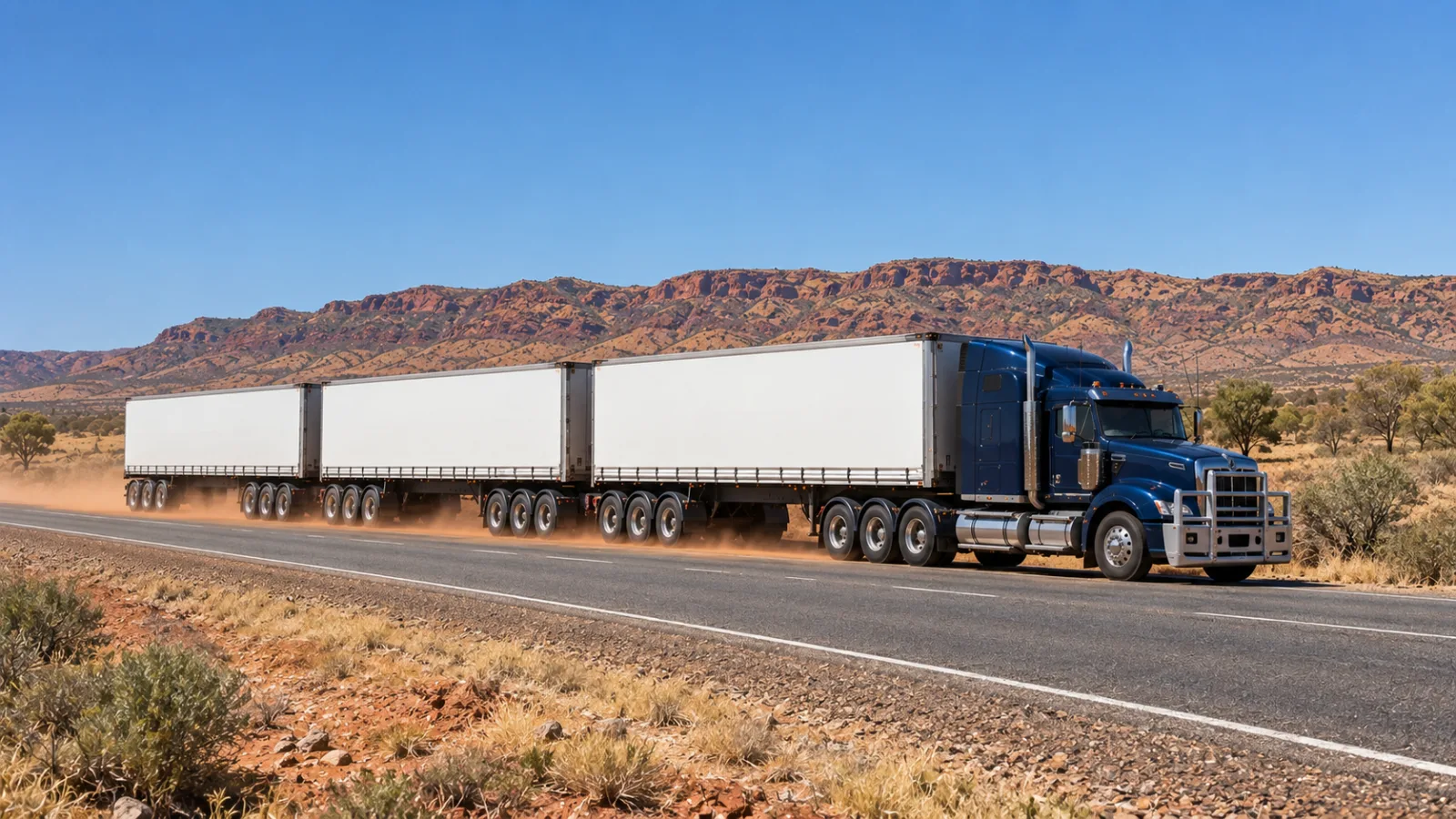 Road train on the Stuart Highway through arid central Australia at midday