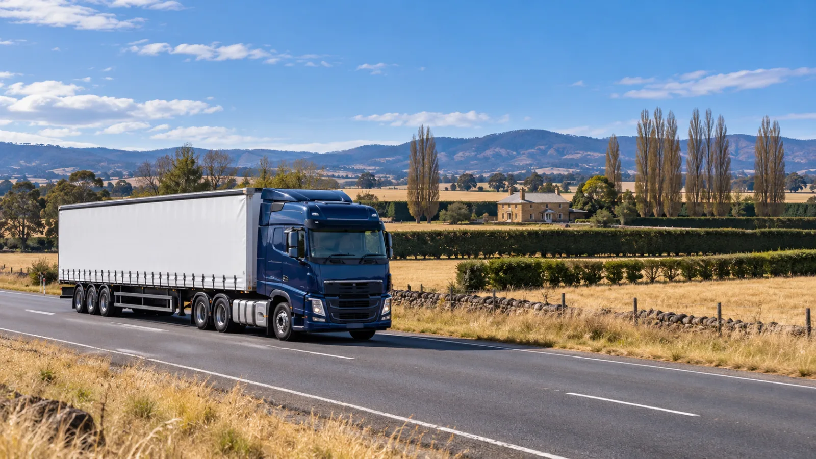 Semi-trailer on the Midland Highway through dry golden midlands grazing country