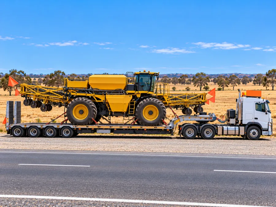 Oversize agricultural machine on a low-loader beside the Hume near Wagga